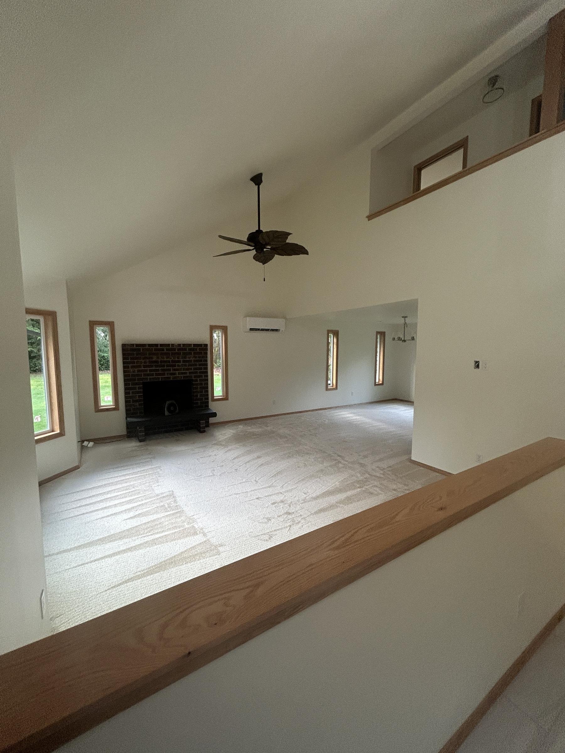 Restored living room with vaulted ceiling and brick fireplace