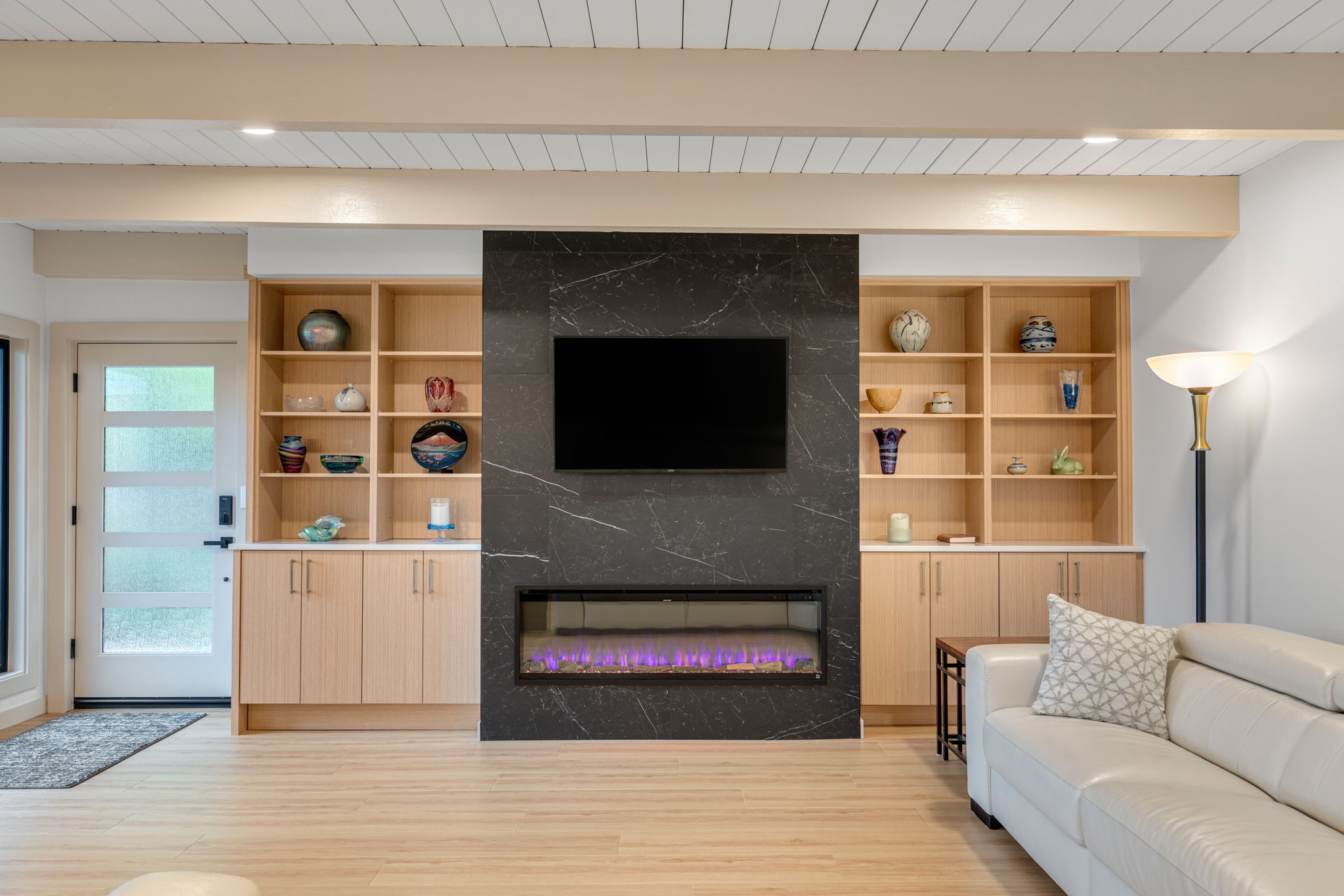 Custom living room with built-in shelving and electric fireplace